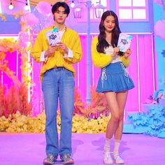 This contains an image of Wonyoung and Sunghoon standing on a stage holding books