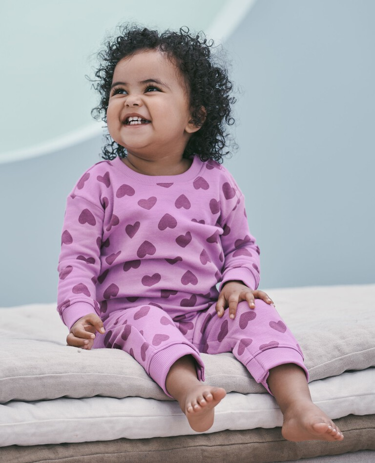 Child wearing colorful organic cotton pajamas from Hanna Andersson, a brand known for high-quality natural fiber clothing for kids.