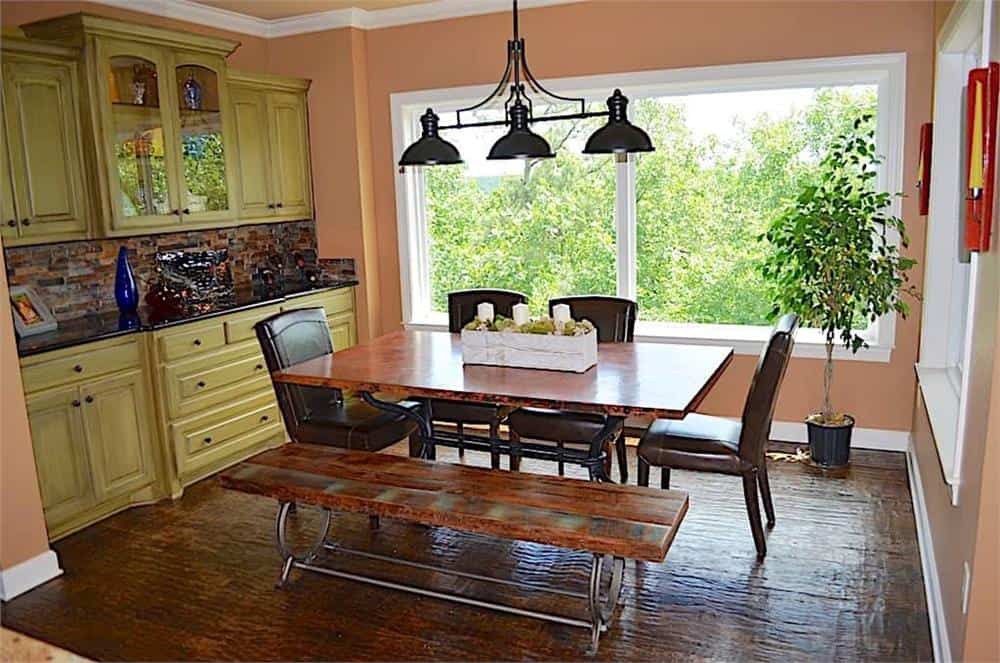 The breakfast nook offers a built-in buffet cabinet and a wooden dining table surrounded by a matching bench and leather upholstered chairs.
