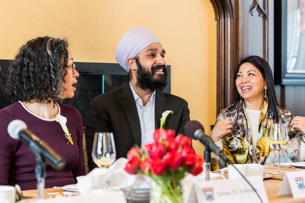 A photo of Simran Jeet Singh sitting in a middle of a meeting, alongside two female experts. 