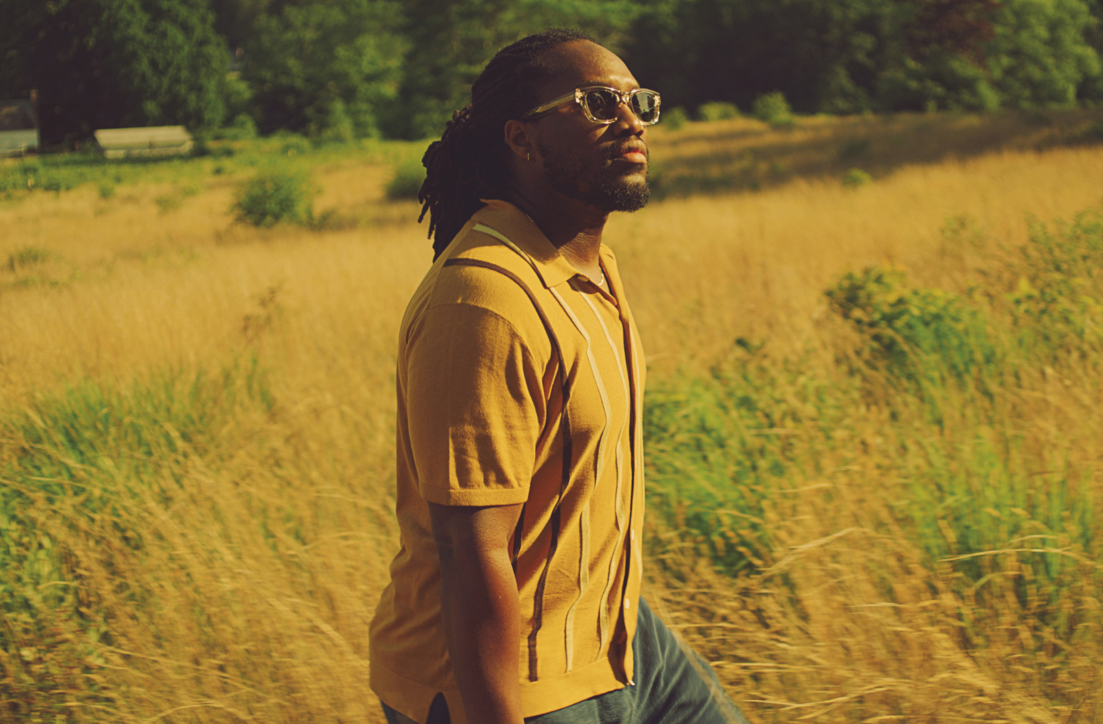 Model standing in a sunny field wearing polarized sunglasses.