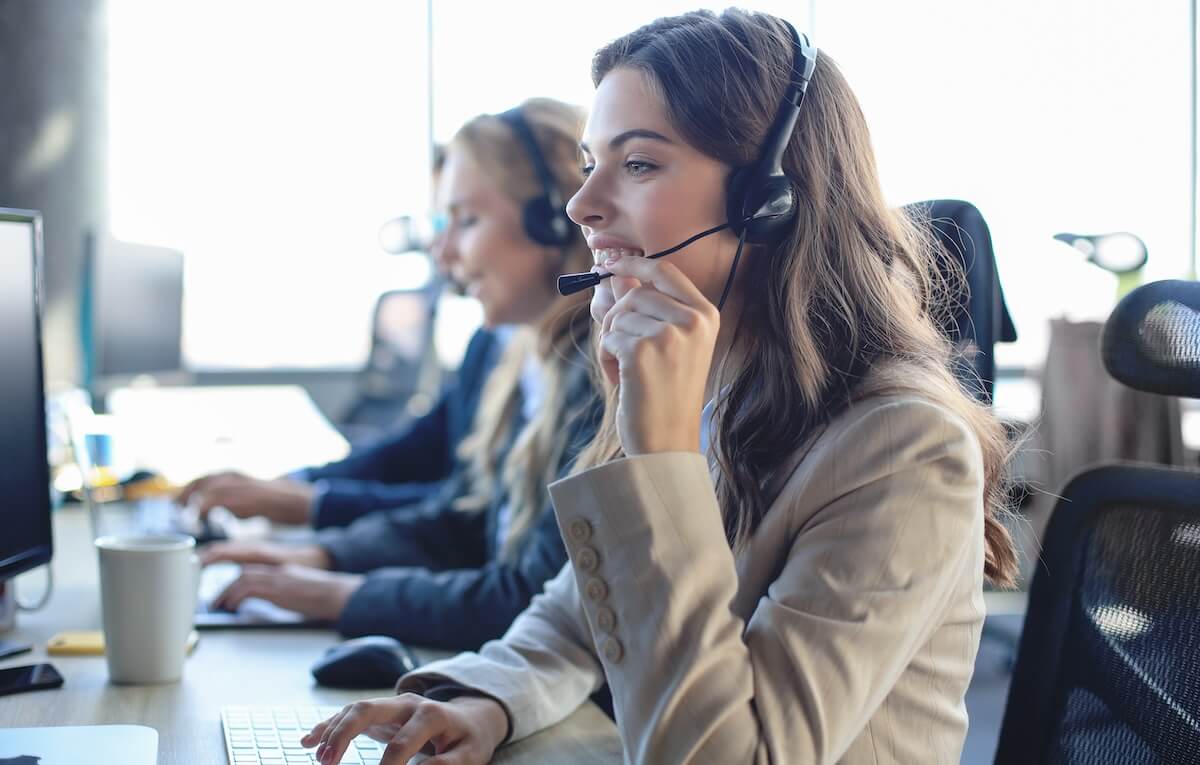 Benefits of AI powered service centers: employee using a headset to talk to a customer