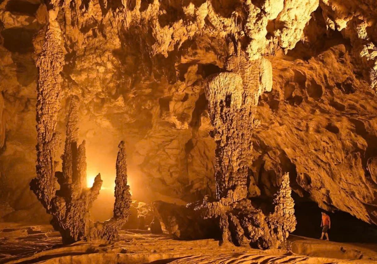 A cave with stalactites and stalagmitesDescription automatically generated