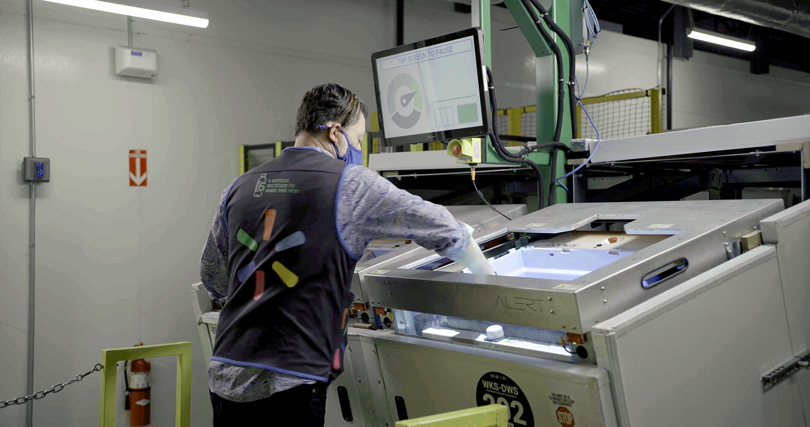 Walmart associate uses a screen-guided system to sort items in an automated fulfillment center, enhancing order speed and accuracy.