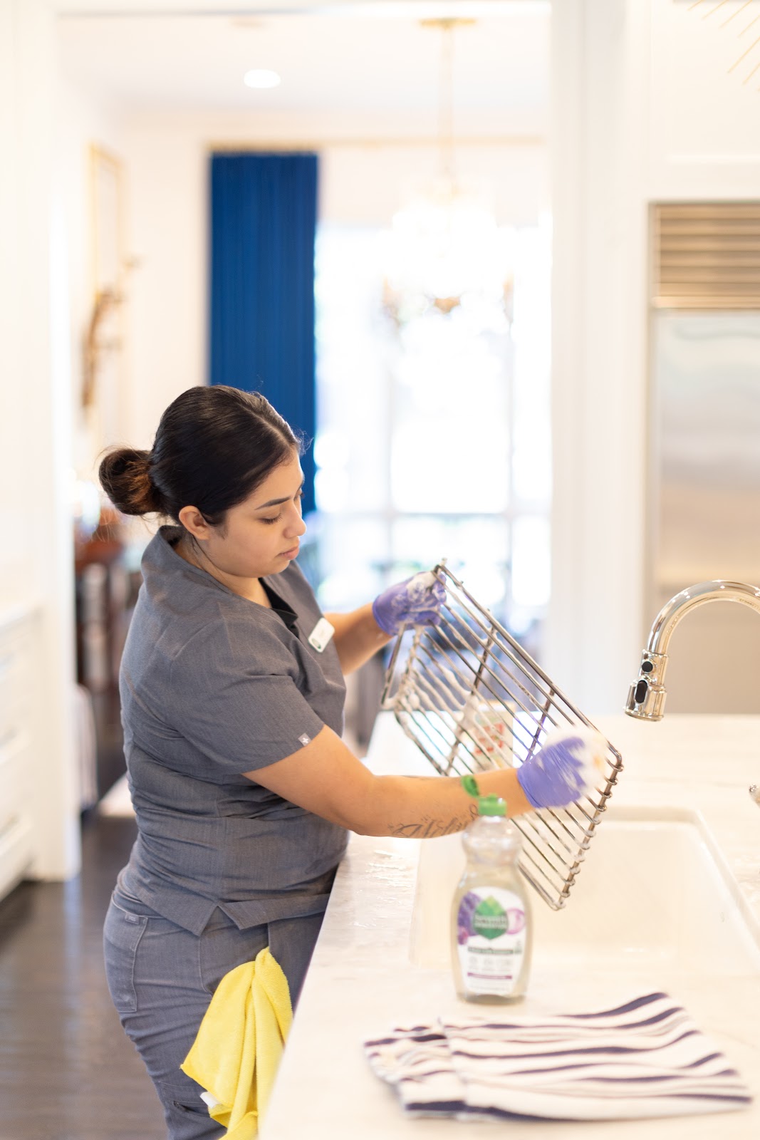 Professional cleaner practicing eco-friendly cleaning in Austin, scrubbing a kitchen rack with sustainable, green cleaning products.