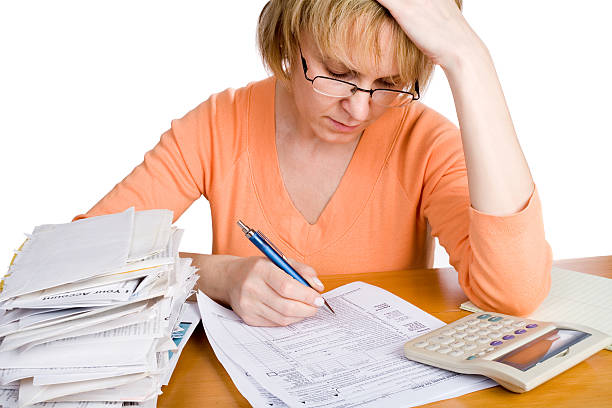 Taxes A woman over a tax form. Isolated on white. Employment Taxes and Payroll Obligation federal tax refund, federal government stock pictures, royalty-free photos & images