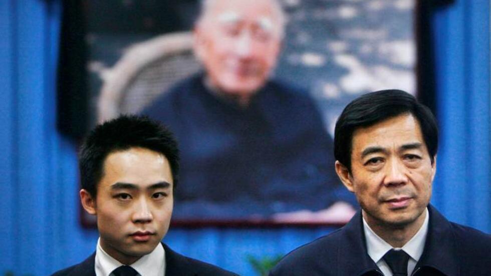 China's then Chongqing Municipality Communist Party Secretary Bo Xilai (R) and his son Bo Guagua stand in front of a picture of his father Bo Yibo, former vice-chairman of the Central Advisory Commiss