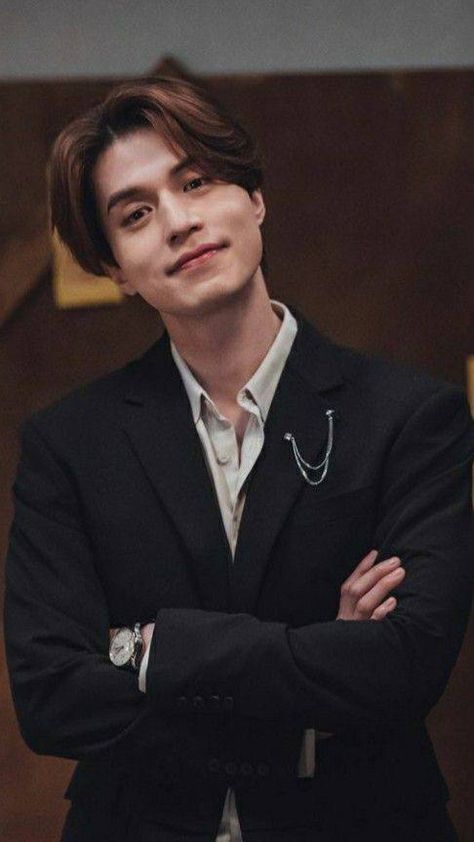 This contains an image of Lee Dong Wook with his arms crossed wearing a suit