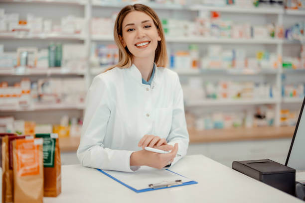 Smiling pharmacist at Washington Health & Drug standing behind the counter, ready to offer expert advice on cholesterol management and fish oil supplements.