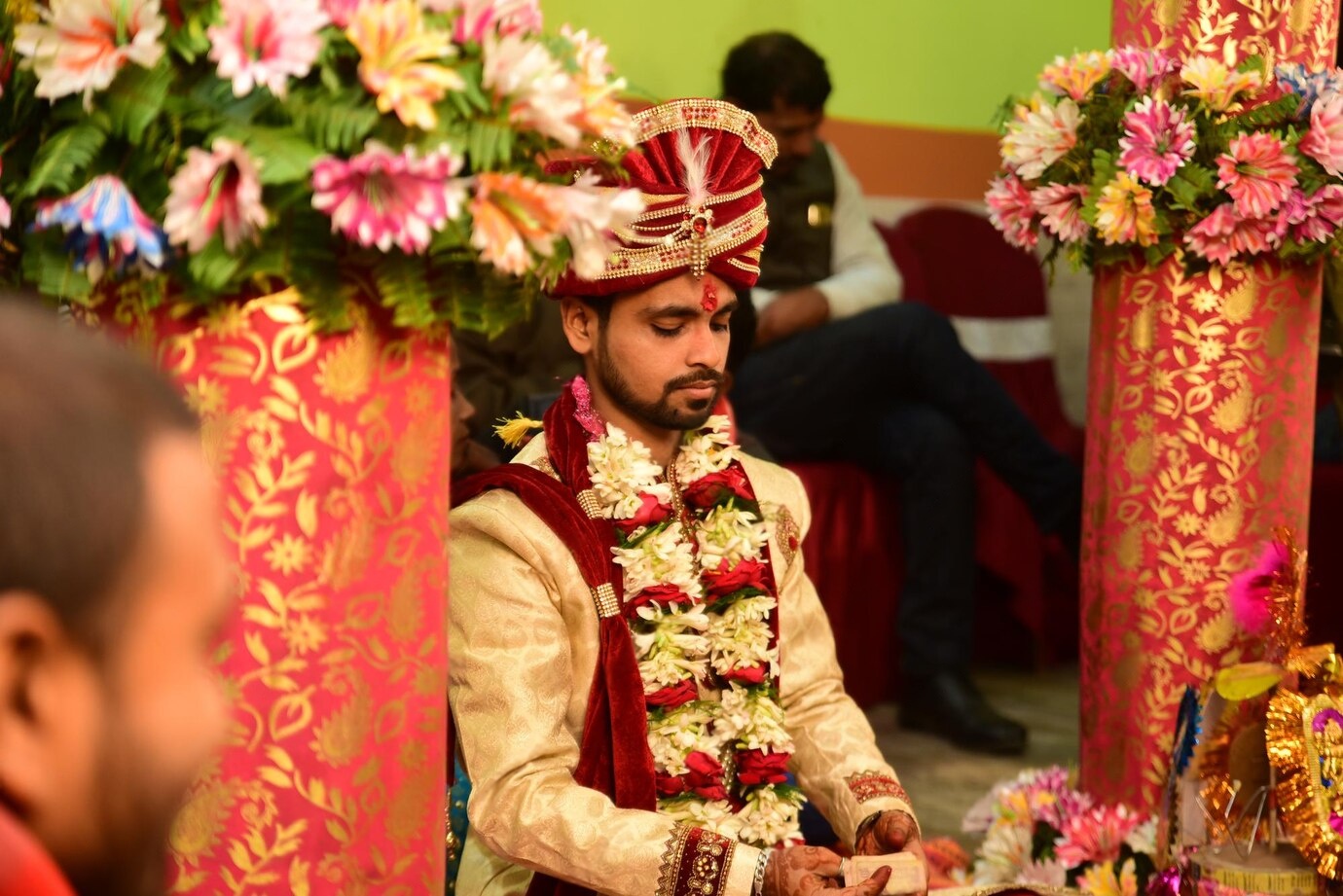 A couple discussing design ideas with a professional mandap decorator in New York City, surrounded by samples of traditional and modern mandap elements for a wedding setup.