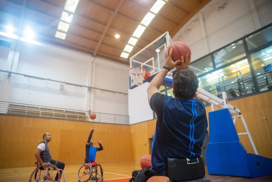  men in wheelchair playing basketball together