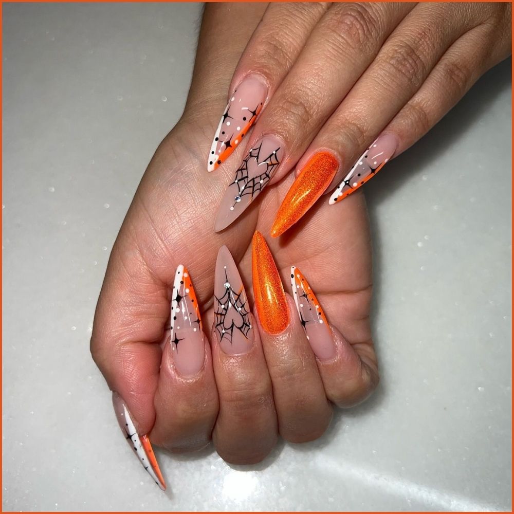 Close up of nails with spooky nails having Spooky Orange Stiletto Nails