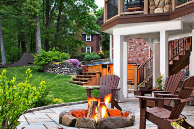 combining hardscaping and decking for a unique outdoor living space patio with stone campfire custom built michigan