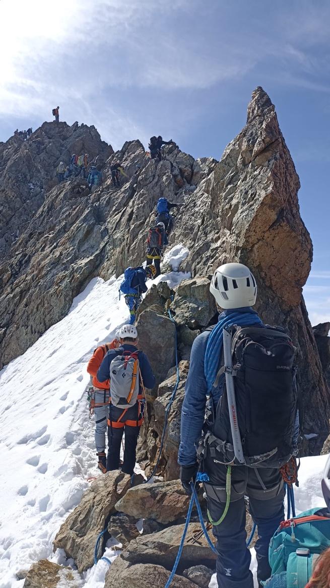 A group of people climbing a mountainAI-generated content may be incorrect.