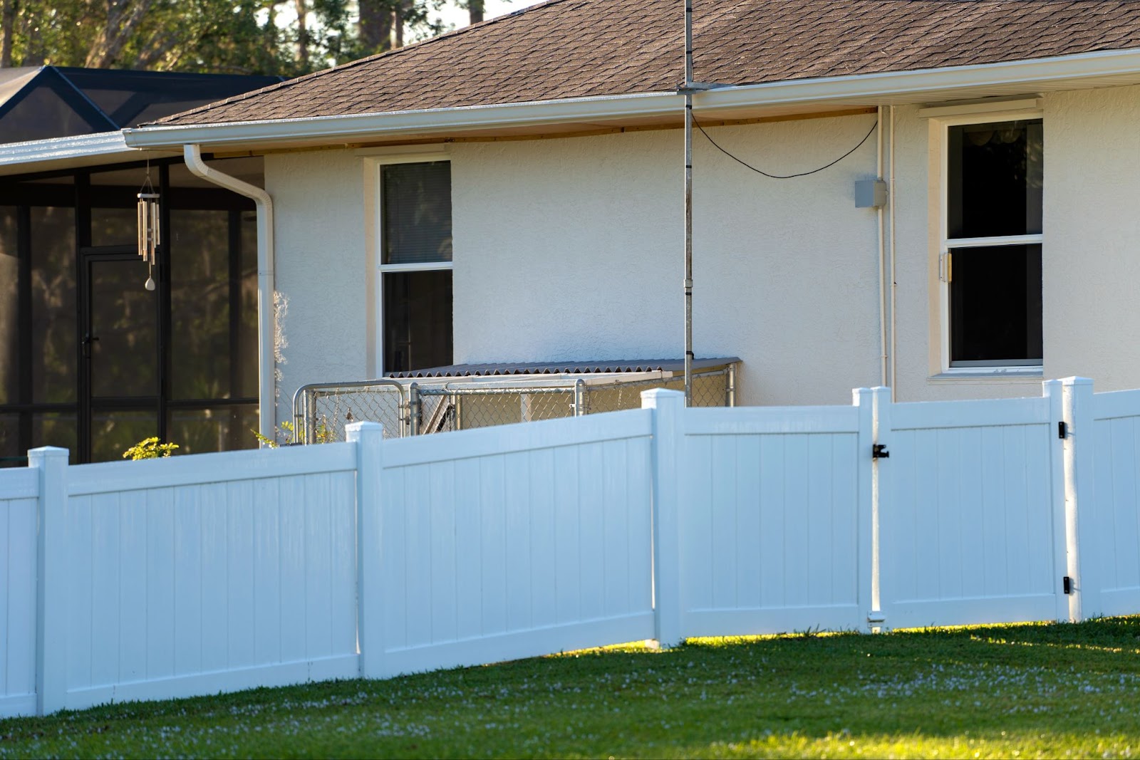 Vinyl fence on the side of a home with a gate. 