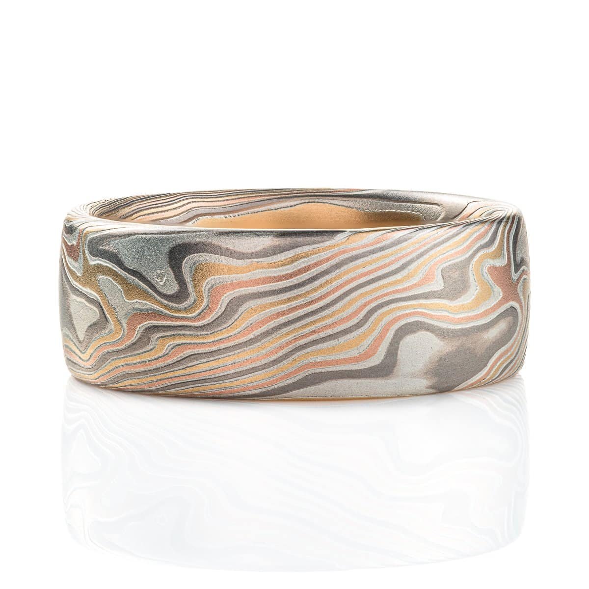 Mokume gane mens wedding ring made with red gold, yellow gold, palladium and silver. Made in a twisting pattern with an etched finish for slight texture.