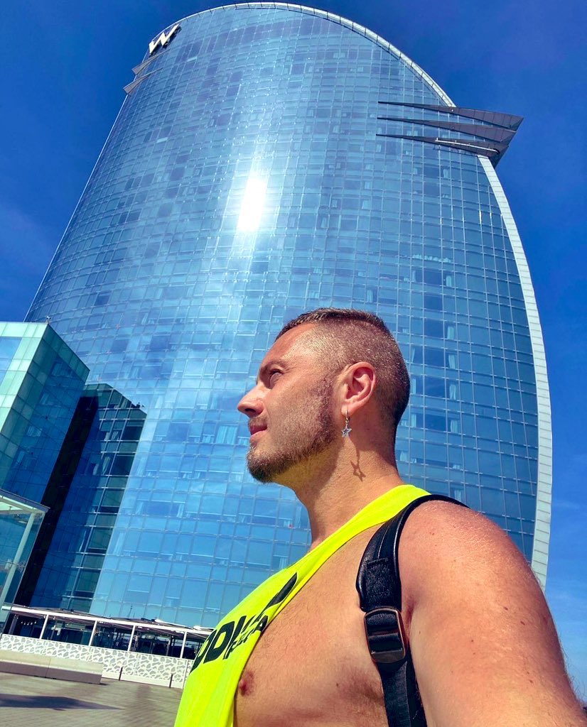 Mars Barcelona taking a selfie outside in yellow addicted extreme racer back tank top and star earring