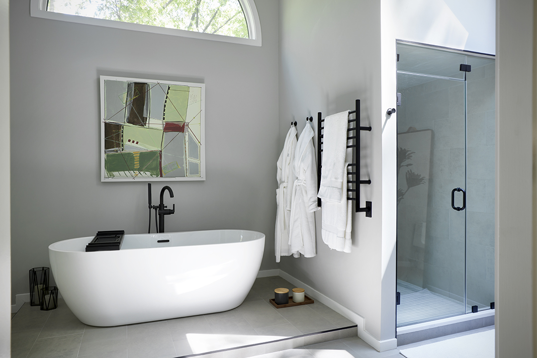 Large primary bath with a soaking tub, walk-in shower, grey walls, and matte black fixtures and hardware