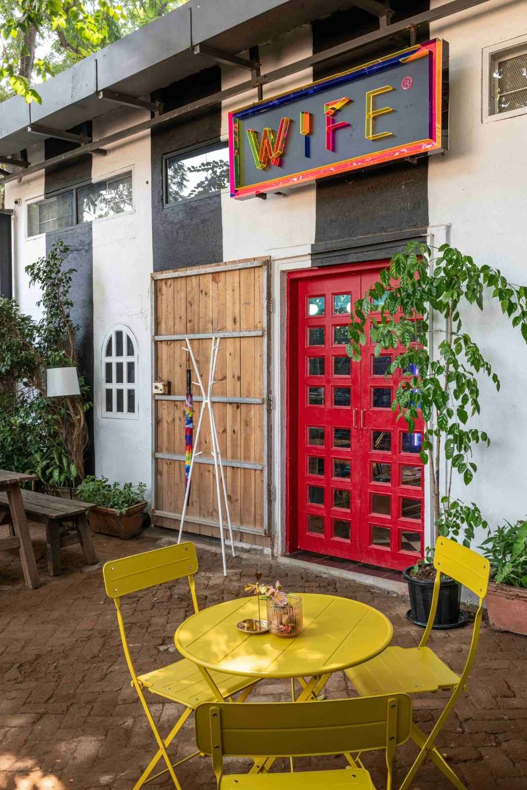 Outdoor workspace with a bright yellow table and chairs in front of a building.