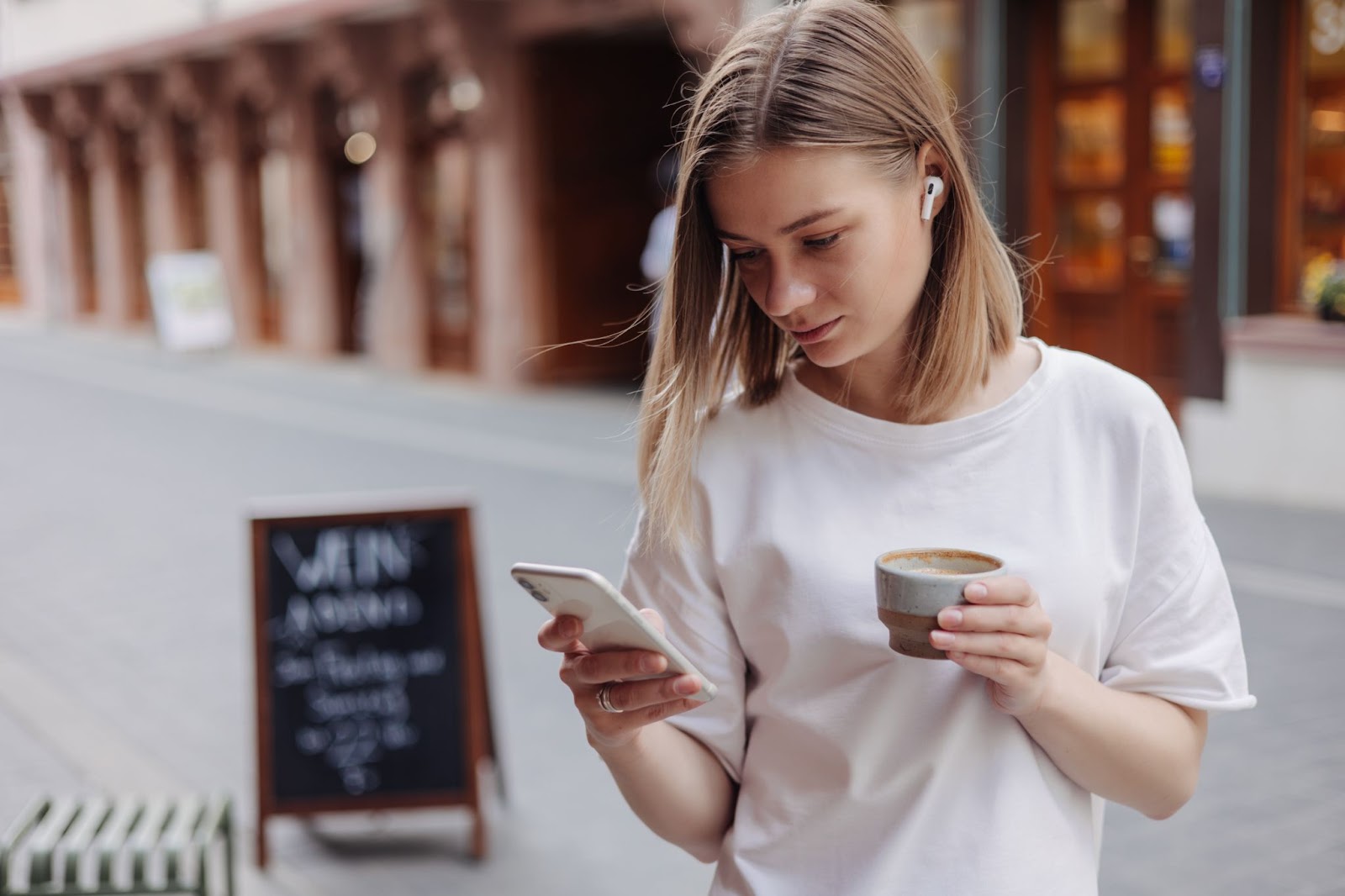 woman on a street looking at a phone