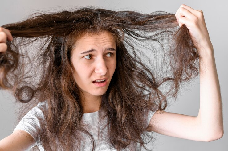 Woman frustrated with her tangled and frizzy hair