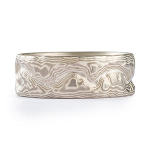 Custom designed mokume gane ring made with dark and light silver colored metal, three dimensional texture made to look like a topographic map.