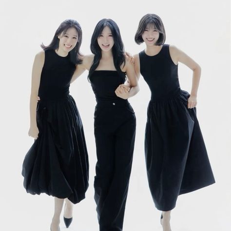 This contains a picture of A picture of FIFTY FIFTY members Saena, Aran, and Sio in black dresses posing for a photo together, with one holding her hand on her hip