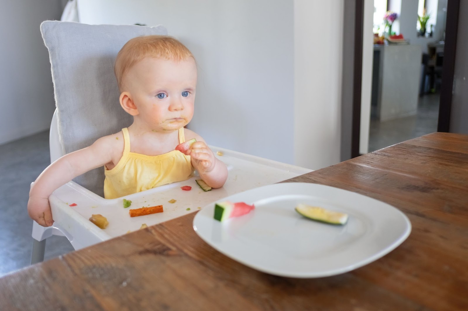 A little girl eating a piece of watermelon