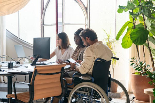 man with disabilities working with colleagues in the office