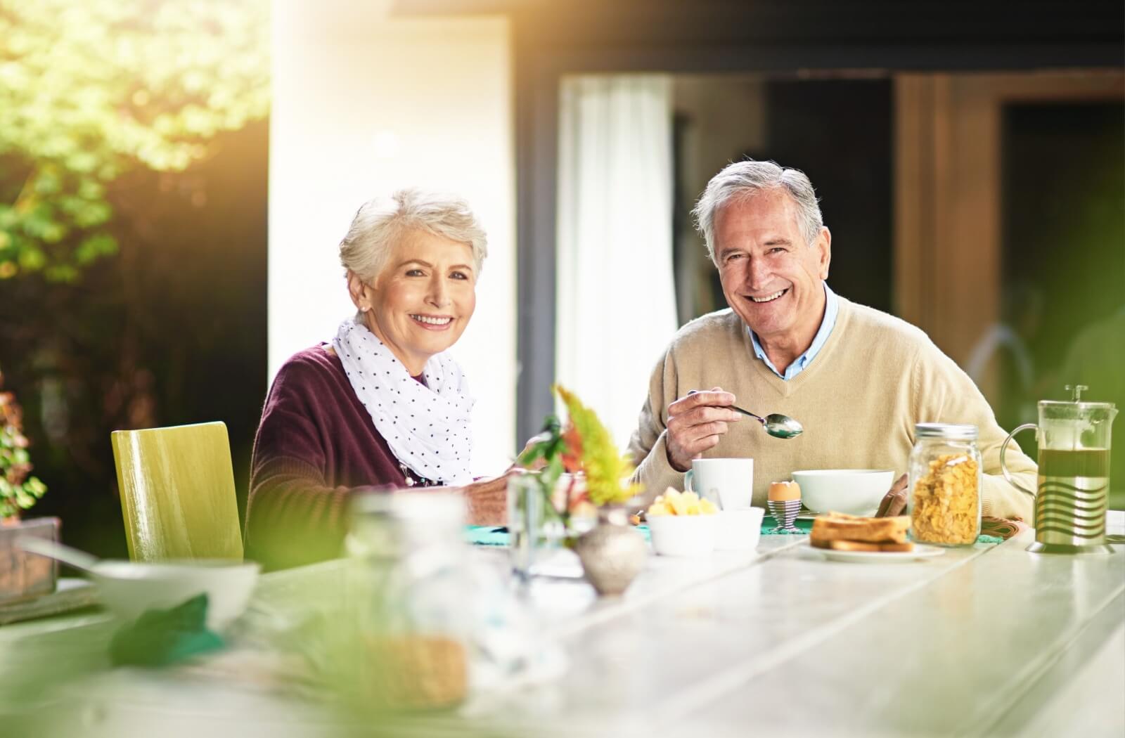 A happy senior couple enjoy a balanced meal to aid in dementia prevention.