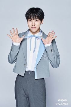 This  contain an image of  Cha Woongki in a suit and bow tie holding his hands up to the camera with both hands