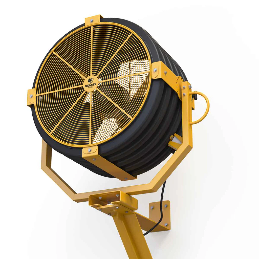 A directional industrial floor fan pointed toward a workspace.