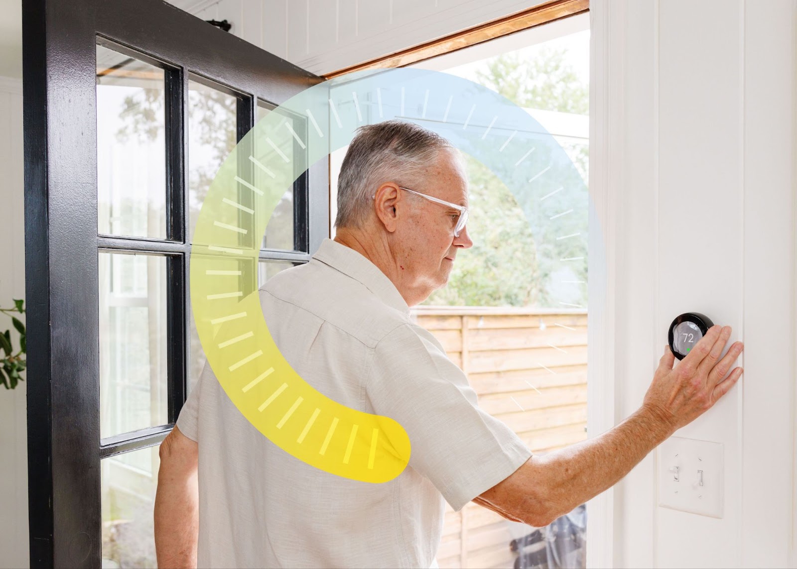 Older man adjusting his thermostat as he leaves his home on a summer day.