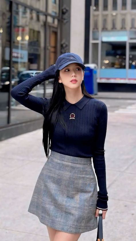 This contains an image of BLACKPINK's Jisoo wearing a skirt and hat walking down the street with her hand on her head