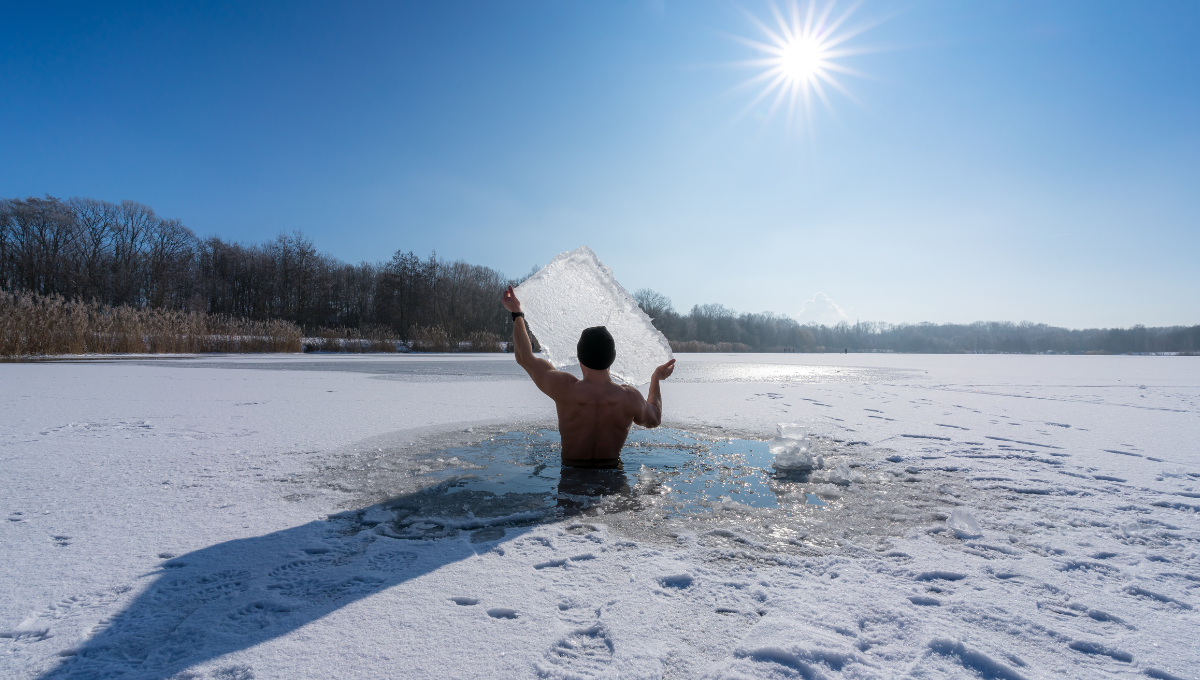 A man holding a block of ice taking an ice bath.