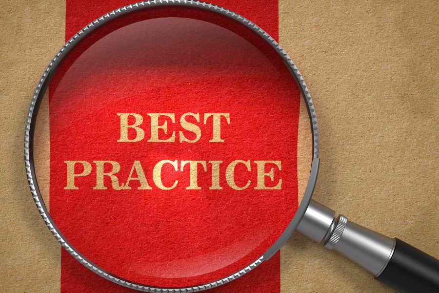 Magnifying glass highlighting the phrase "Best Practice" on textured paper background.