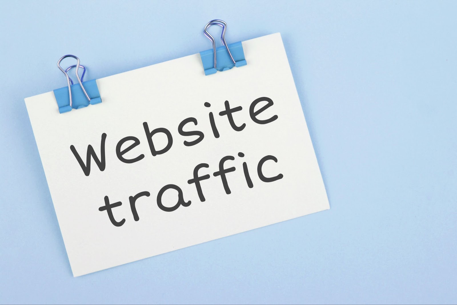 Words “Website traffic” on a piece of paper with clips attached.   H2: How SEO Delivers Results