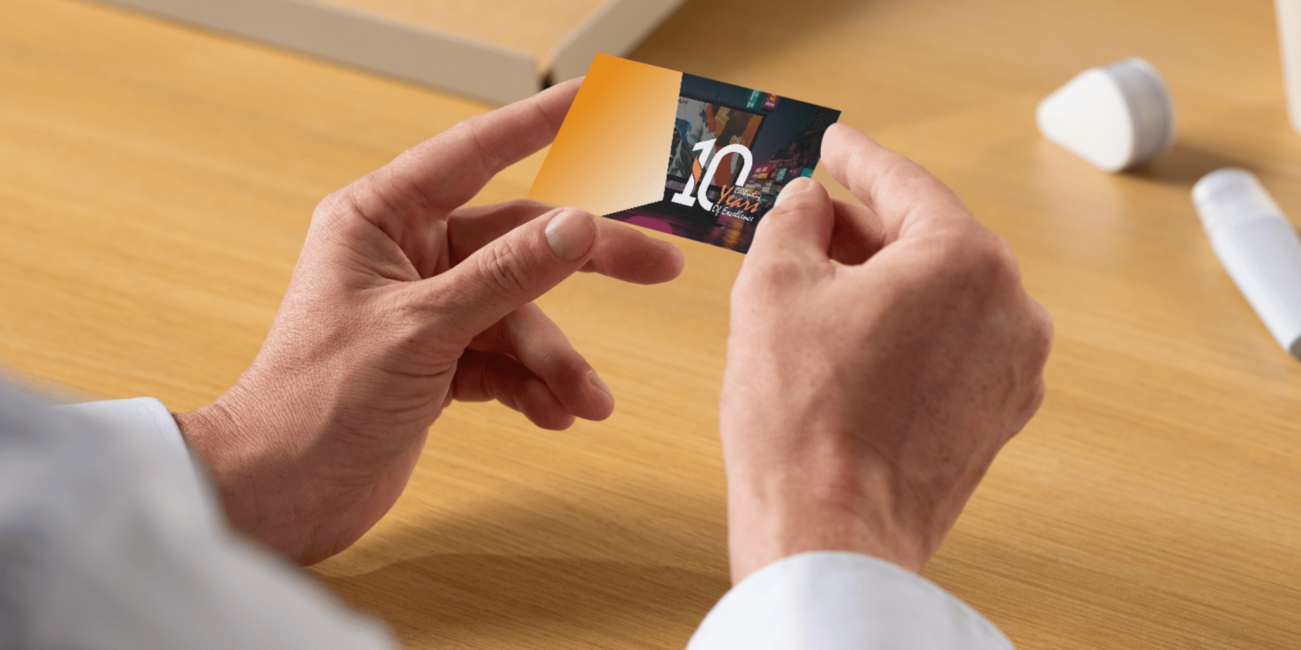 DAC Qatar – Your Right Digital Printing Partner in Qatar A person holding a premium business card with a '10 years of excellence' design, representing high-quality digital printing services.