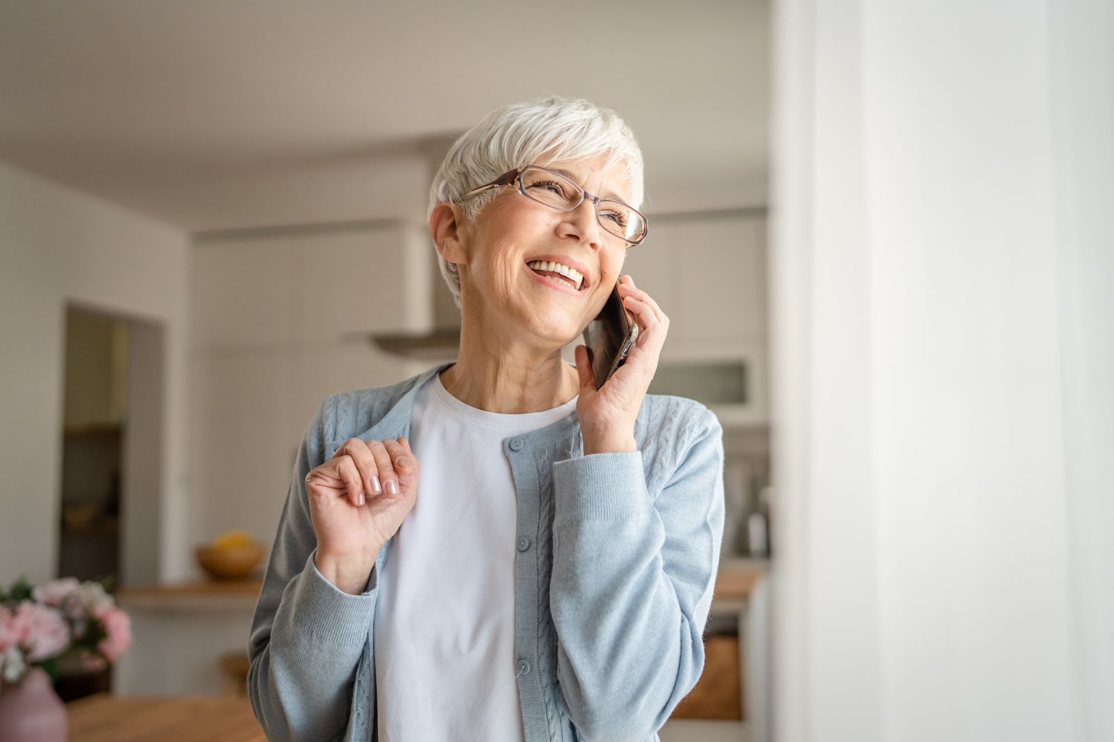 A senior woman smiling while using her new smartphone to call her family.