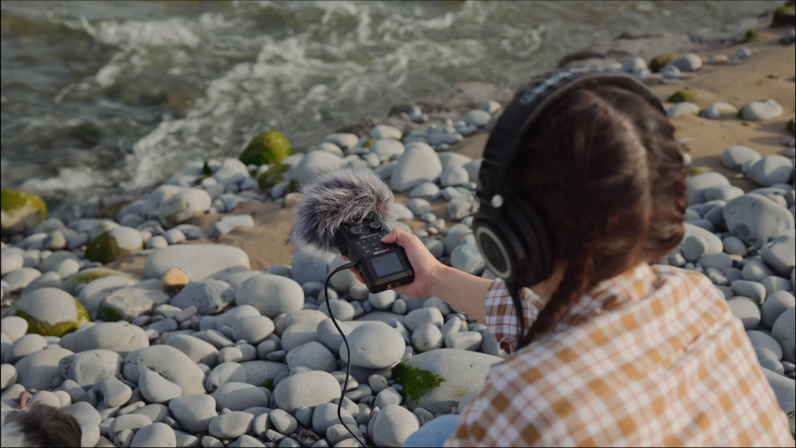 Female filmmaker testing audio equipment. 