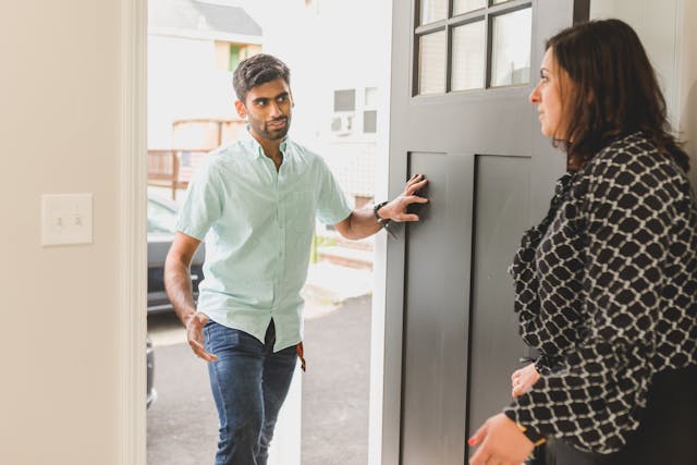 Person opening door letting person inside