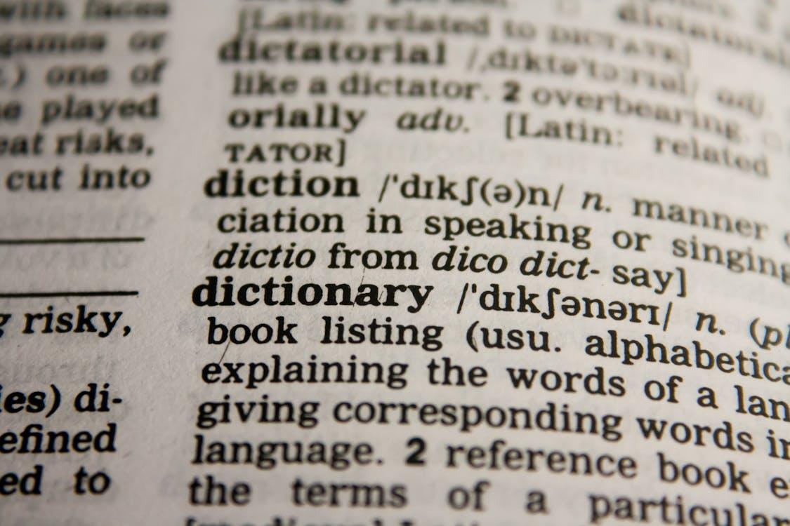Free Detailed close-up view of a dictionary page highlighting the word 'dictionary' and its definition. Stock Photo