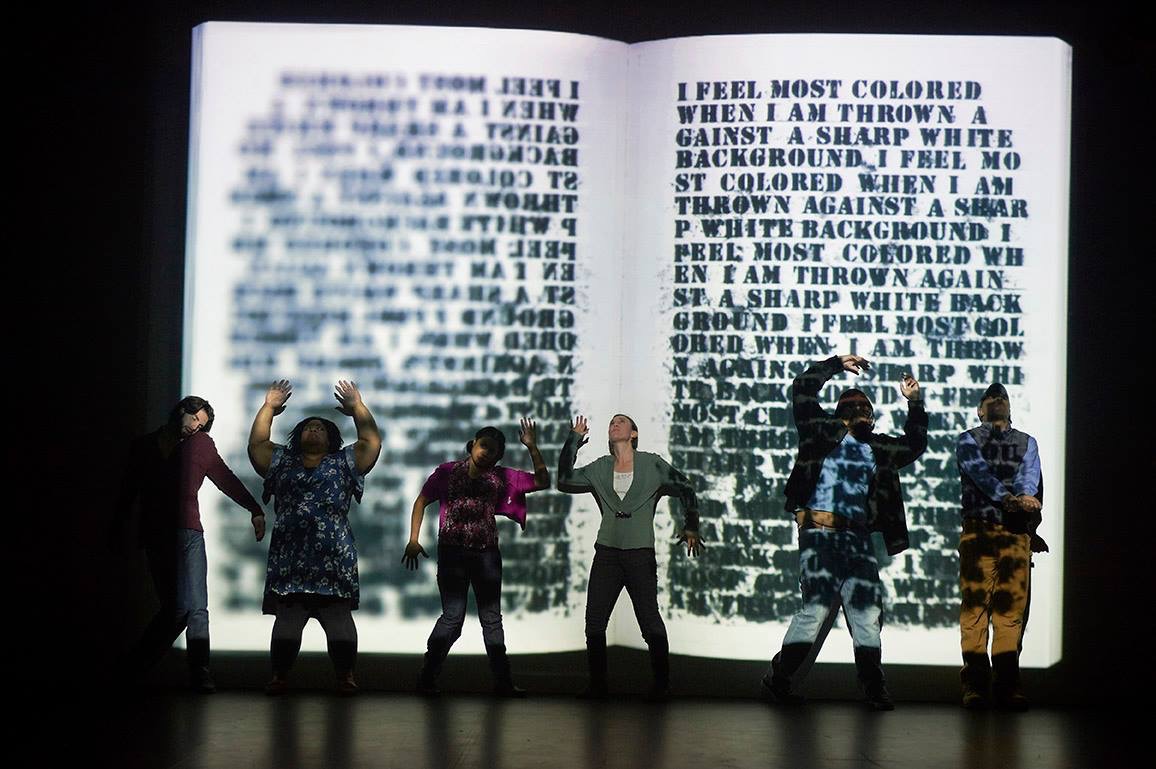 Image: Bill Cottman's projection and artists in performance of Claudia Rankine's "Citizen: An American Lyric" at Intermedia Arts, 2017. Six people in various poses stand in front of a project, which shows a mirror image of artist Glenn Ligon's piece Untitled (I Feel Most Colored When I Am Thrown Against A Sharp White Background)
1992. Photo by Bill Cottman.