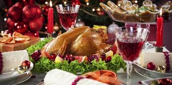 A turkey on a plate with wine glasses and a tree in the background

Description automatically generated