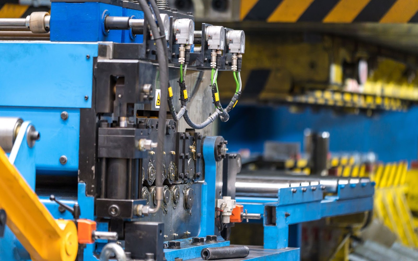 Progressive stamping machine in action, showing multiple stages of metal shaping in a single operation.