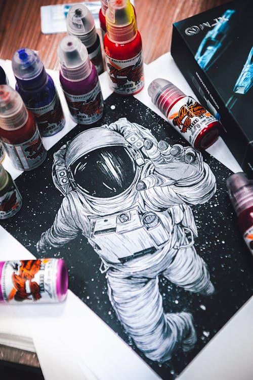 Artistic illustration of an astronaut surrounded by vibrant paint bottles, showcasing creativity and imagination.