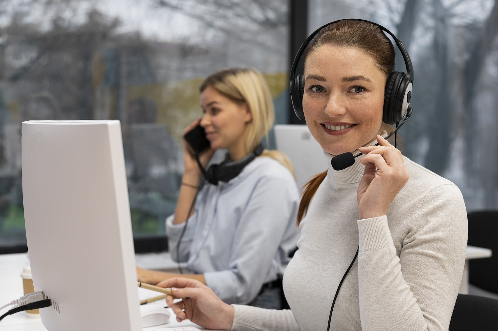 Young women working on computer with headset