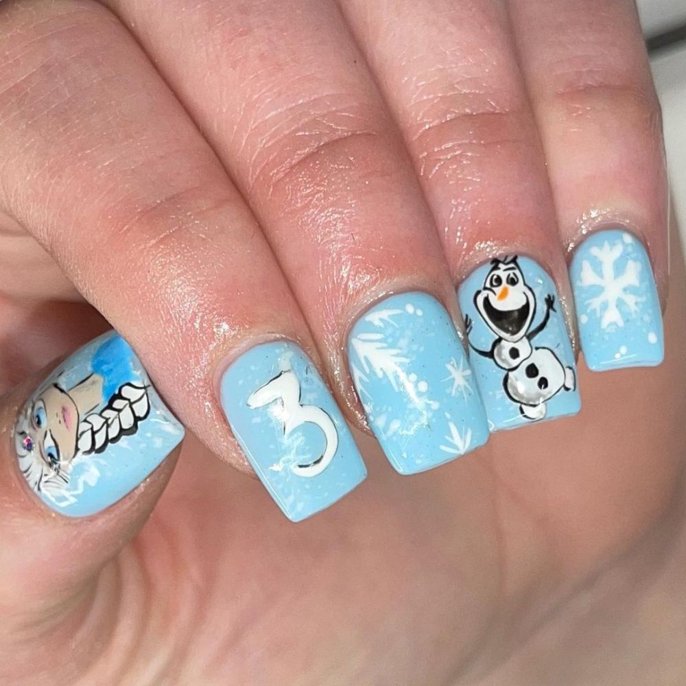 Close up of hands with blue winter nails having Elsa's theme nails