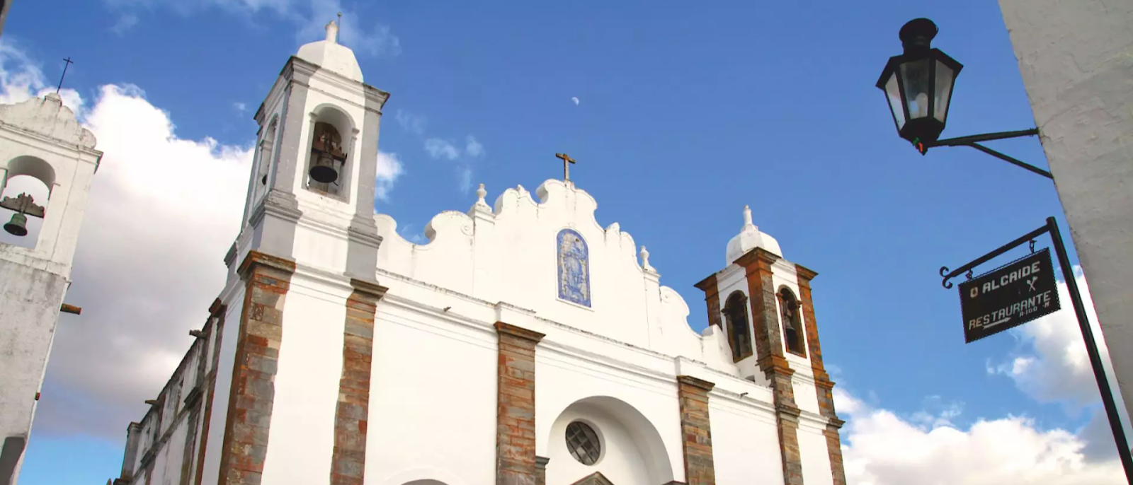 Fachada branca da Igreja Matriz de Nossa Senhora da Lagoa em Monsaraz, Alentejo; conheça este tesouro histórico e descubra onde fica Monsaraz.