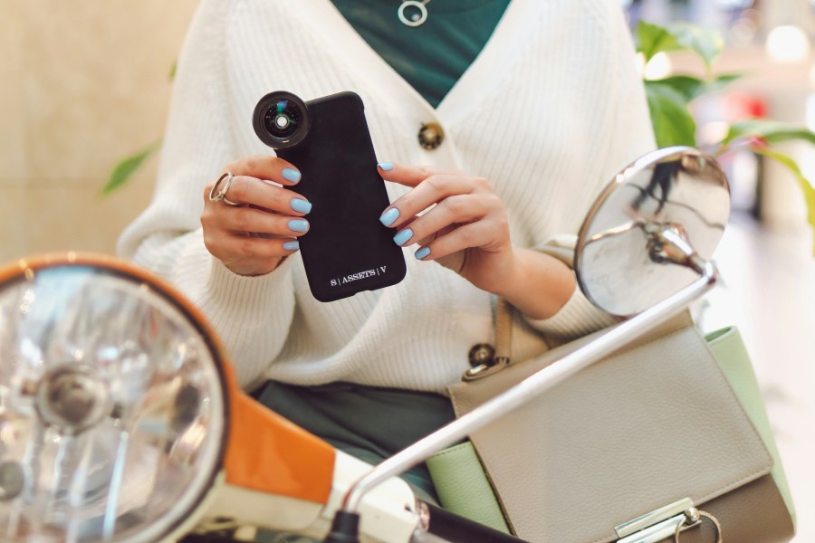 woman in white blazer holding phone